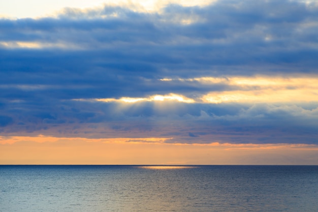 Heldere cumuluswolken tegen de blauwe hemel. Avondrood Natuurlijke achtergrond. zeegezicht