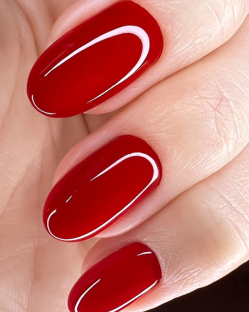 Heldere feestelijke rode manicure op vrouwelijke handen Nagels ontwerp