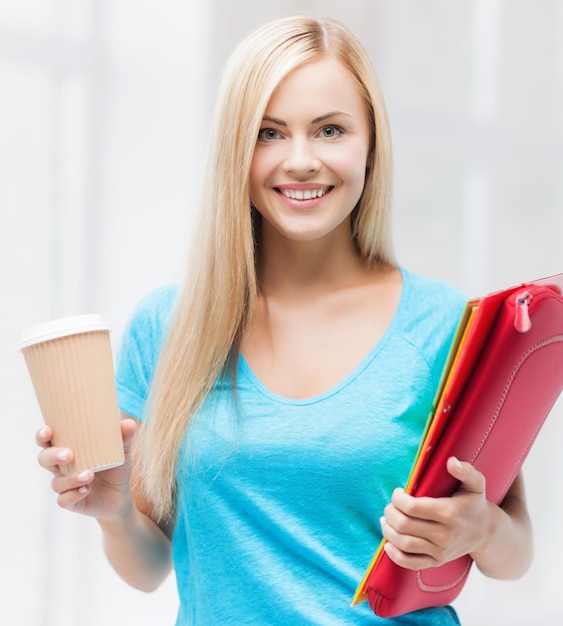 heldere foto van lachende student met mappen en kopje koffie