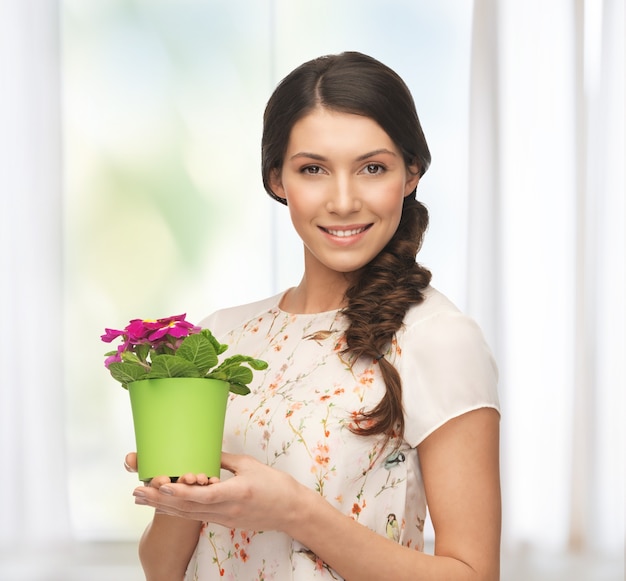 heldere foto van mooie huisvrouw met bloem in pot