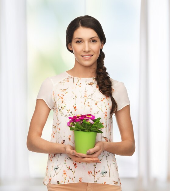 heldere foto van mooie huisvrouw met bloem in pot