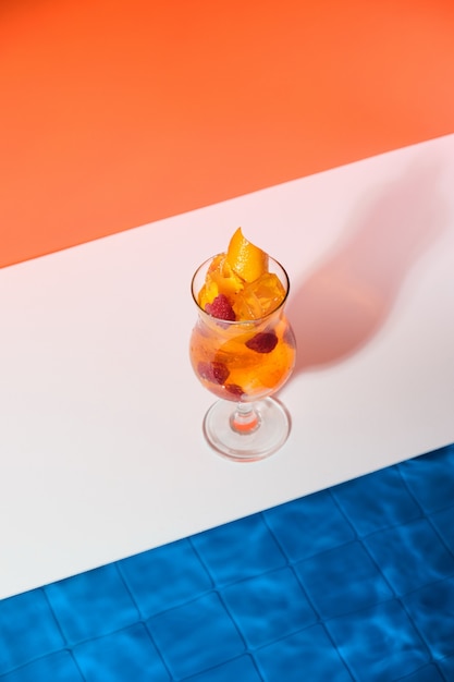 Heldere, koele sinaasappelcocktail met frambozen en ijsblokjes bij het zwembad Toning verfrissend drankje