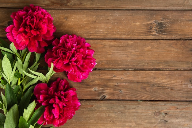 Heldere pioen bloemen op bruin houten tafel. Dames dag of bruiloft achtergrond.