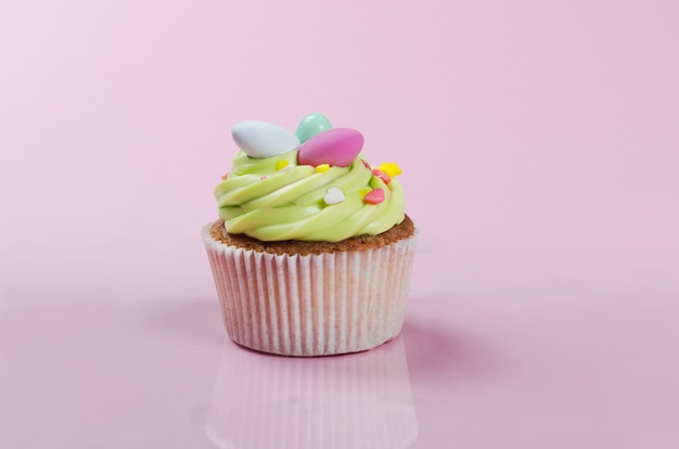 Heldere pistache Pasen cupcake met decoraties close-up op roze achtergrond