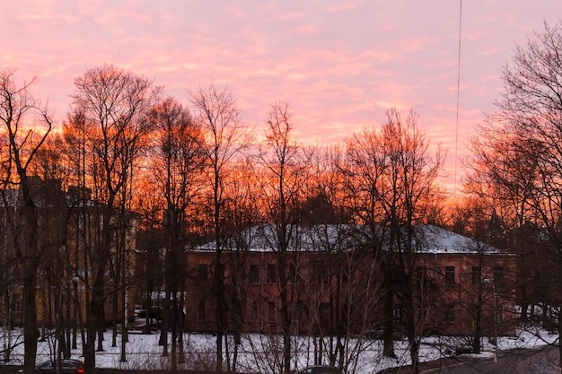 Heldere rode zonsondergang in de winter over oude huizen