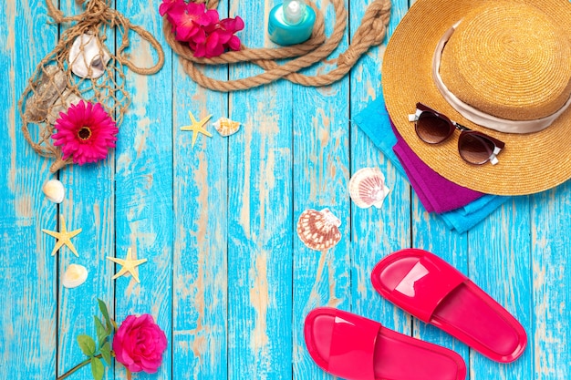 Foto heldere samenstelling van vrouwelijke strandaccessoires op blauwe houten achtergrond