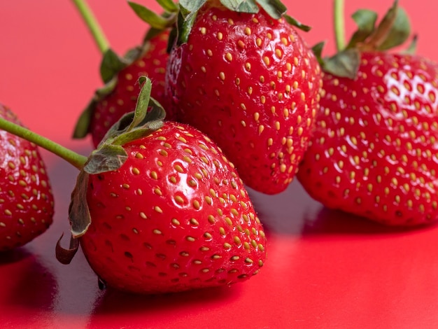 Heldere sappige rijpe aardbeien op een rode achtergrond. Vooraanzicht, gezonde voeding, vegetarisme