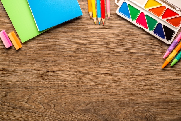 Heldere school accessoires, briefpapier op een houten tafel, kopie ruimte, bovenaanzicht