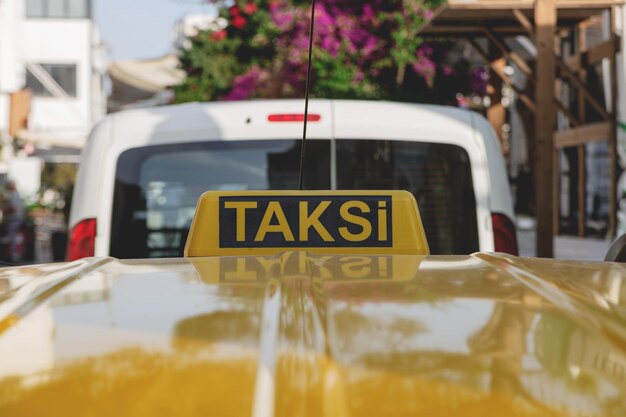 Heldergele taxi teken op het dak van een gele auto op een zonnige dag