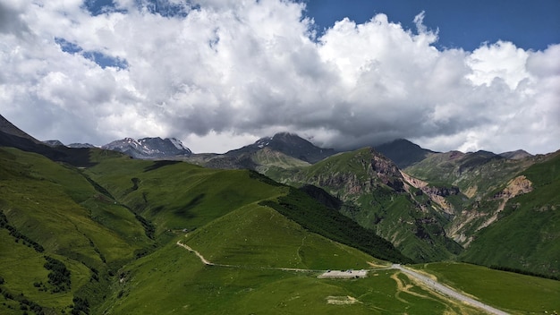 Heldergroene bergen onder de wolken in de zomerdag