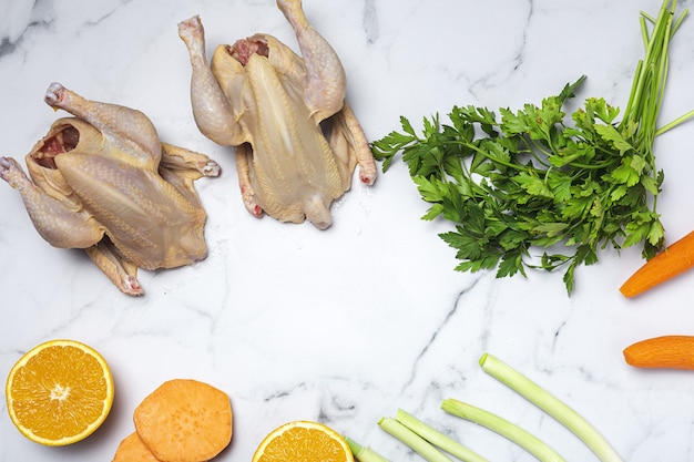 Hele coquelet-kippen met rauwe groenten, klaar om te koken