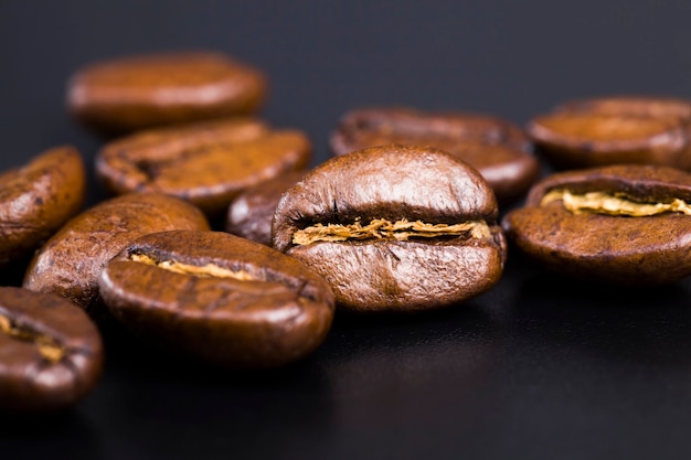 Hele en smaakvolle koffiebonen verspreid in een chaotische volgorde, geroosterd en klaar voor gebruik voor het maken van koffiebonen