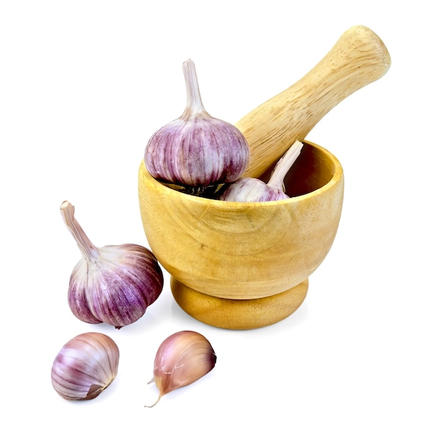 Hele en teentjes knoflookbollen in een houten vijzel en op tafel geïsoleerd op een witte achtergrond