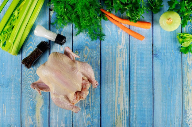 Hele rauwe kip en groenten bereiden voor het koken