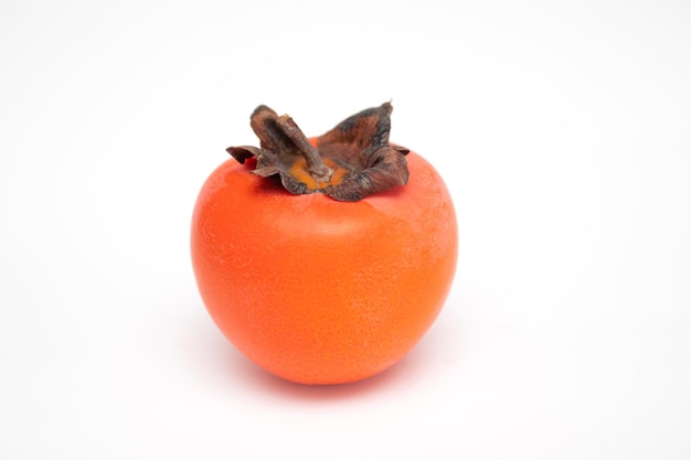 Hele rijpe persimmon op een witte achtergrond.