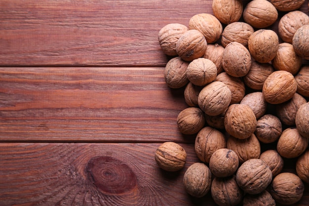 Hele walnoten met plaats voor tekst op houten achtergrond. Een volledige bron van plantaardige eiwitten. Concept - gezond eten.