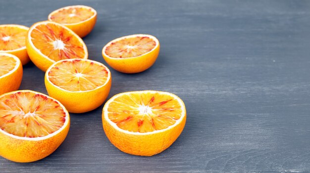 helften van een sinaasappel liggen op een grijze houten achtergrond