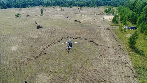 Photo helicopter arrived on green field helicopter landed on yellow grass cloudy day flying drone and