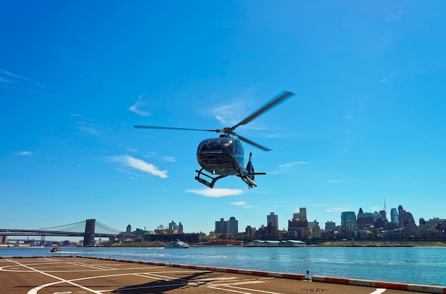 Helicopter and Brooklyn bridge and Manhattan bridge over East River on the background. Bridges connect Lower Manhattan with Brooklyn of New York, USA. Brooklyn Heights on the background.