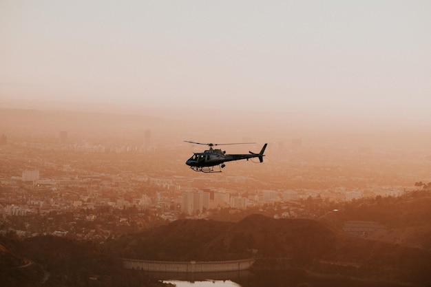 Helikopter vliegt boven de stad tijdens zonsondergang