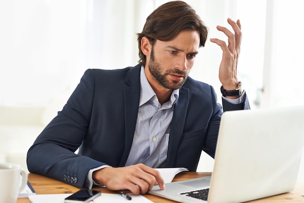 Hell do whatever it takes to get the job done A handsome businessman working on his laptop