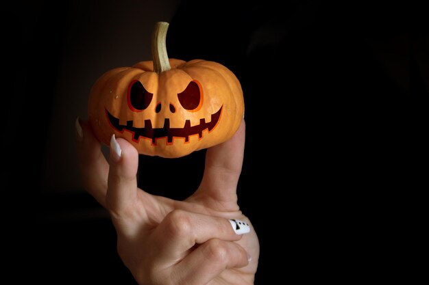 Photo hellaween mask on a pumpkin in hands