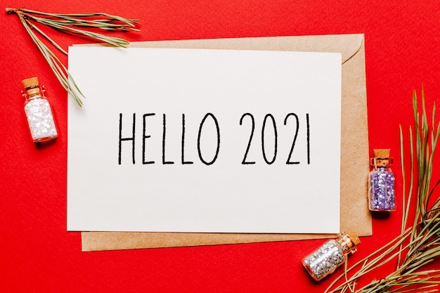 안녕하세요 2021 크리스마스 노트 선물, 전나무 분기와 빨간색 격리 된 배경에 장난감. 새해 개념