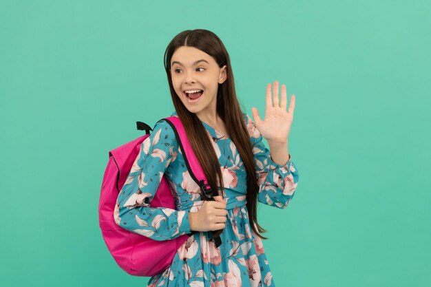 Hello back to school knowledge day concept of education beautiful kid with long hair on blue background september 1 happy childhood child with school bag happy teen girl carry backpack