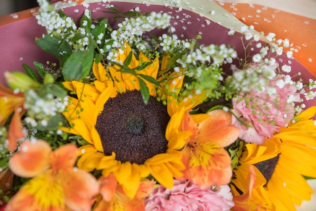 こんにちは、ひまわりとカーネーションの美しい秋の花束を明るい背景にクローズ アップ季節の花組成グリーティング カード