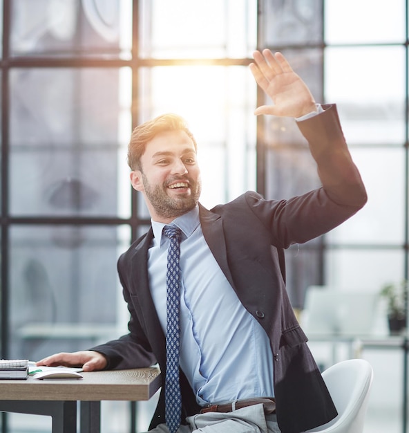 Photo hello by man in office indoor waving hand