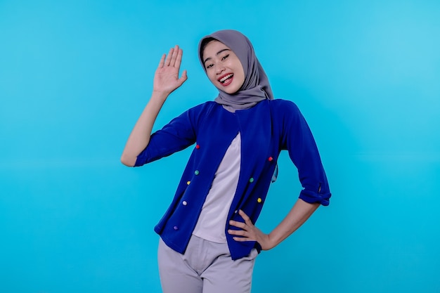 Hello nice to meet you. cute and friendly outgoing blond with wearing hijab waving raised palm in hi and greeting gesture or saying bye smiling