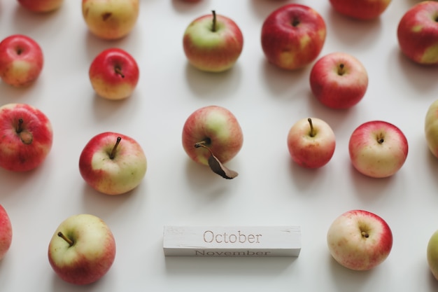 Hello october autumn card with fresh red apples on white background top view