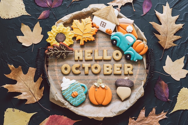 こんにちは10月。黒の背景に色とりどりの秋のクッキー。秋のコンセプト