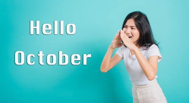 Hello October Portrait Asian beautiful happy young woman shouting with hands cover mouth