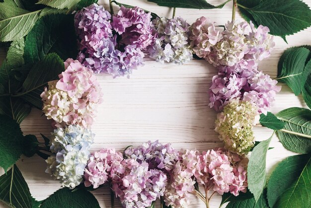 Foto ciao primavera buona festa della mamma festa della donna bella cornice di fiori di ortensia su legno bianco rustico piatto giaceva biglietto di auguri di ortensie colorate rosa blu verde bianco con spazio per il testo