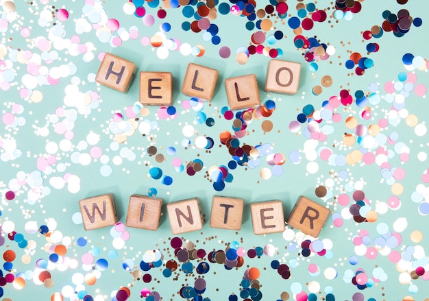 Hello winter word written on wood block Greeteng card concept on mint background