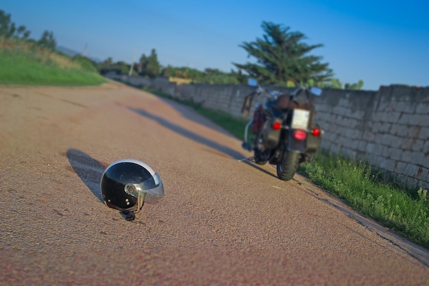 Helm en motorfiets op een lege weg in de schemering