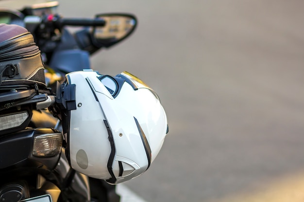 Helmet on sports motorcycle on road. Motorbike parked on a street. Freedom and travel concept.