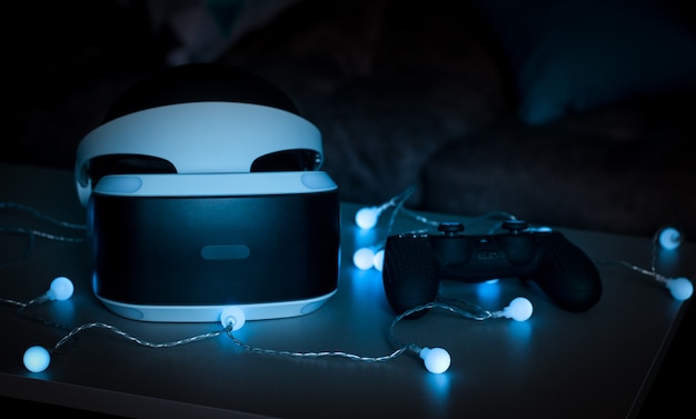 Foto il casco della realtà virtuale. nuova esperienza nel gioco. emozioni incredibili, riposo eccezionale. gli occhiali per la realtà virtuale si trovano nelle luci al neon.