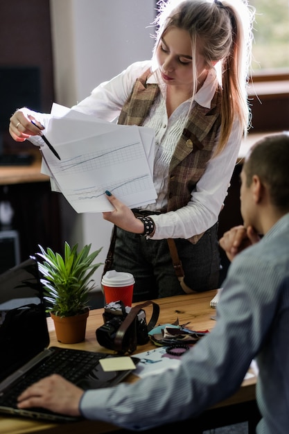 Help assistance planning cooperation. assistant manager secretary showing graphs to her colleague. business working routine. office workspace