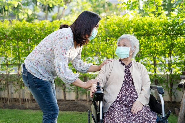 help aziatische senior vrouw op elektrische rolstoel en het dragen van een masker om covid19 coronavirus te beschermen