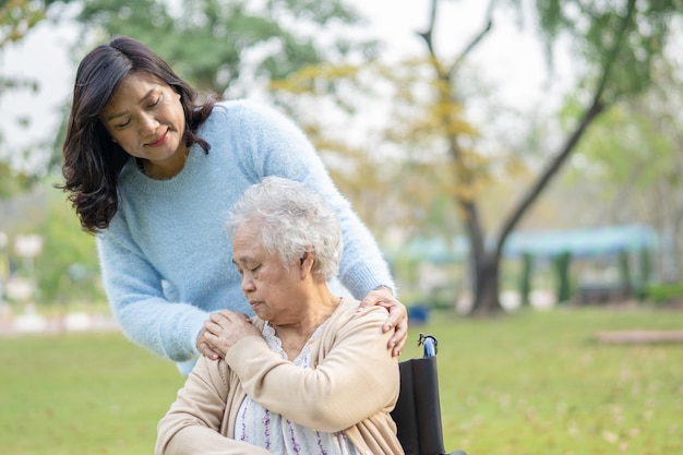 Help and care Asian senior or elderly old lady woman use walker with strong health while walking at park in happy fresh holiday.