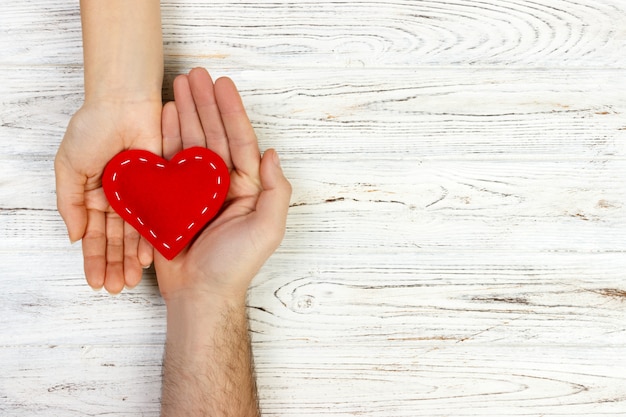 Help, Heart in Hand on wood background. Valentine day concept. copy space