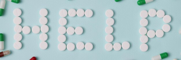 Help lettering made with white round pills pharmaceutical
medicament oral tablets