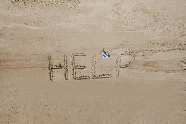 Help me de inscriptie op het zand Help me alsjeblieft op een tropisch strand