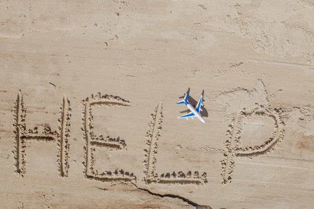 Aiutami l'iscrizione e l'aereo sulla sabbia. mi aiuti per favore. su una spiaggia tropicale.