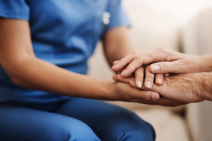 Foto help zorgverlener en oudere vrouw die handen vasthouden op de bank voor gezondheidszorg consultatie of mededogen lens flare verpleegster en oudere patiënt voor hoop vertrouwen of medisch gesprek in een bejaardentehuis