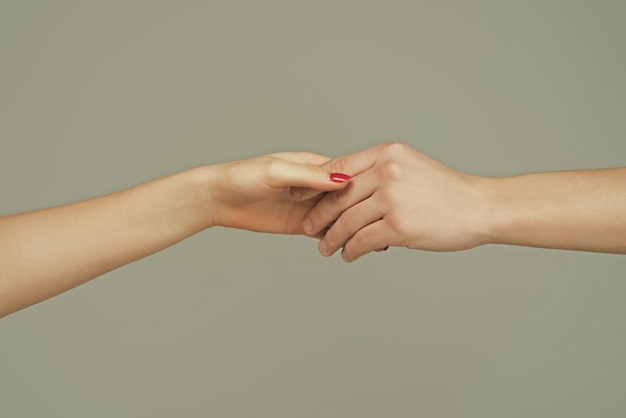 Foto helpende hand die de hand van dichtbij vasthoudt en een hulphandredding geeft, helpend gebaar of handenreddingsrela