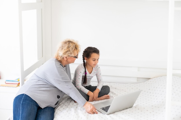 Photo helpful granny. helpful loving granny assisting her cute granddaughter making homework