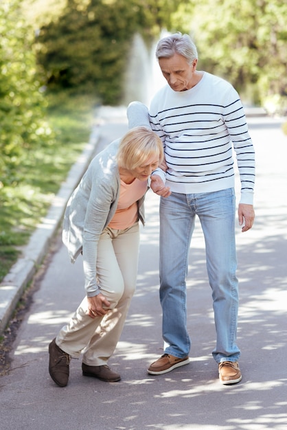 彼の年老いた妻を気遣い、戸外を歩きながら彼女が一歩を踏み出すのを手伝う、親切な引退した平和な男